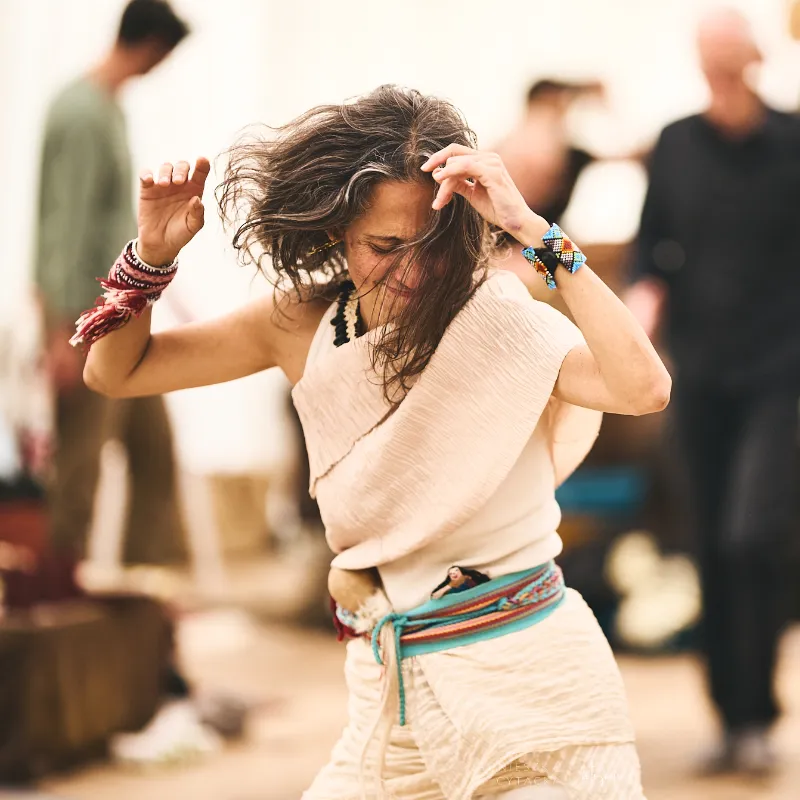 Camille Barrios dancing freely at a summer movement medicine gathering